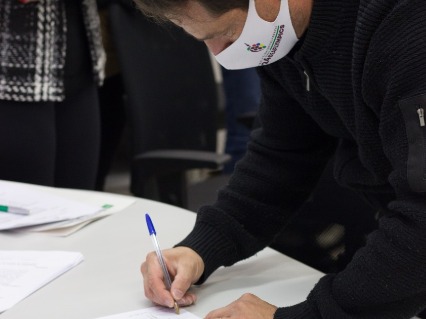 Gustavo signing the paper.