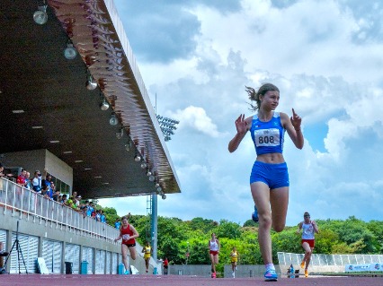 A girl sprints to the finish while others behind